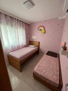 a bedroom with two beds and a rainbow wall at Apto Novo Maracanã/Tijuca in Rio de Janeiro