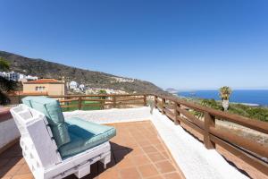 une chaise assise sur un balcon donnant sur l'océan dans l'établissement Casa Los Grabados, piscina, vistas, barbacoa y zen, à Icod de los Vinos
