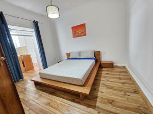 1 dormitorio con 1 cama y suelo de madera en Casa Semedo, en Montemor-o-Novo