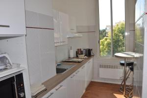 a white kitchen with a sink and a window at Cannes Plage in Cannes