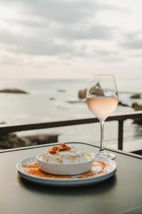 ビアリッツにあるHôtel de La Plageのテーブルの上に一皿とワイン1杯