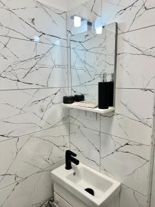 a white bathroom with a sink and a mirror at Apus de vis in Cluj-Napoca