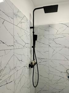 a shower in a bathroom with a white marble wall at Apus de vis in Cluj-Napoca