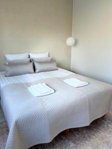 Una cama blanca con dos toallas encima. en Arctic Luxury Apartment, en Rovaniemi