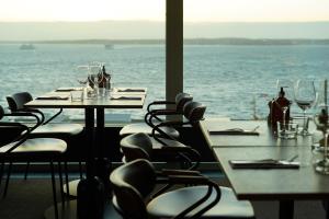 un restaurante con mesas y sillas con vistas al océano en Clarion Hotel Sea U en Helsingborg