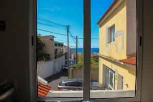 een raam met uitzicht op een straat bij A m a r - 450m from the beach in São Roque