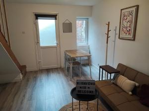 una sala de estar con un sofá y una mesa en Maison 2 chambres Centre-Ville, en La Fère 5 fotos más