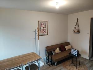a living room with a couch and a table at Maison 2 chambres Centre-Ville in La Fère