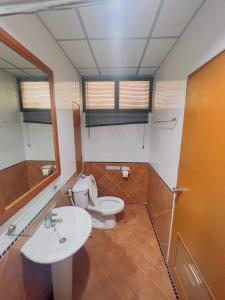 a bathroom with a toilet and a sink and a mirror at Royal Vista in Patong Beach