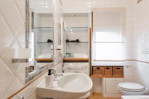 a white bathroom with a sink and a toilet at Studio Suite Aurelia Antica in Rome