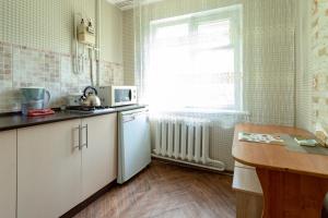 eine Küche mit einem weißen Kühlschrank und einem Fenster in der Unterkunft Дуглас in Petropawlowsk
