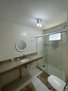 y baño con lavabo y ducha acristalada. en Apartamento 3 Quartos em Frente à Praia do Forte, en Cabo Frío