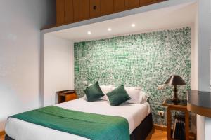 a bedroom with a large bed with a green wall at Studio Suite Aurelia Antica in Rome