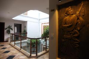 une porte avec une statue d'une femme sur un mur dans l'établissement Bonjour D'An Nam Hotel, à Hanoï