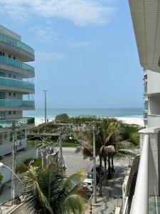 uma vista para uma praia com palmeiras e para o oceano em Apartamento 3 Quartos em Frente à Praia do Forte em Cabo Frio