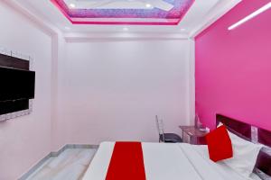 加濟阿巴德的住宿－Super OYO The Prima Residency，一间设有一张粉红色墙壁的床的房间