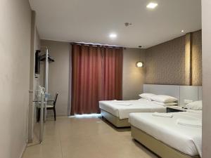 Pokój hotelowy z 2 łóżkami i biurkiem ze stołem w obiekcie Hotel Jelai @ Temerloh, Pahang w mieście Temerloh