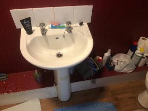 a bathroom with a white sink in a room at Room in town centre in Saint Helens