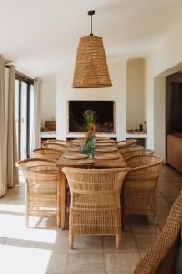 uma sala de jantar com uma mesa e cadeiras de vime em Buff and Fellow by the Bay em Groot Brak Rivier
