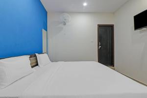 a large white bed in a room with a blue wall at OYO Hotel Rudra Palace Near Phoenix United Lucknow in Charbagh