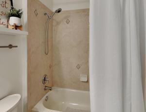 a bathroom with a white shower curtain and a toilet at 365 Cinnamon Beach in Palm Coast