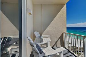 two white chairs on a balcony with the ocean at Inn at Summerwinds #1403 in Navarre