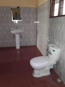 Łazienka z białą toaletą i umywalką w obiekcie SELOUS RIVER VIEW LODGE w mieście Kwangwazi
