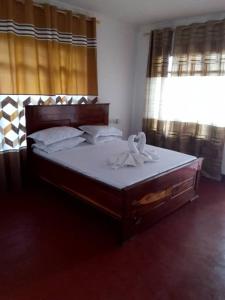 1 dormitorio con 1 cama grande con sábanas y almohadas blancas en SELOUS RIVER VIEW LODGE, en Kwangwazi