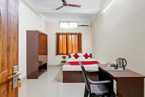 een hotelkamer met een bed, een bureau en een wastafel bij OYO Flagship Lucky 7 in Dispur