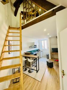 uma cozinha de conversão loft e uma sala de jantar com uma escada loft em L'Herboriste - Appartements meublés em Gien