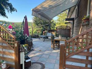 a patio with a table and chairs and an umbrella at Sandys Cozy Stone Cottage in Maulbronn
