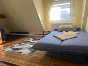 um quarto com uma cama azul e um piso xadrez em Sandys Cozy Stone Cottage em Maulbronn