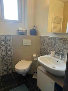 uma casa de banho com um lavatório branco e um WC. em Sandys Cozy Stone Cottage em Maulbronn