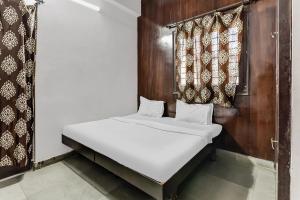 a small bedroom with a bed and curtains at Unique Residency in Udaipur