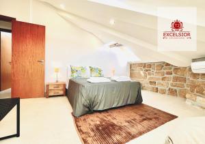 1 dormitorio con cama y pared de piedra en Exclusivo no centro histórico, en Vila Real