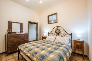um quarto com uma cama, uma cómoda e um espelho em La Casina di Radi em Monteroni dʼArbia