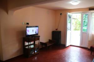 salon z telewizorem z płaskim ekranem na stojaku w obiekcie Achi Guest House w mieście Machindżauri