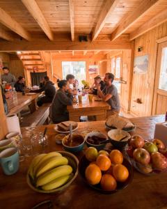 un grupo de personas sentadas en una mesa con fruta en El Refugio Casa de Montaña en San Martín de los Andes