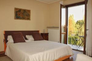 a bedroom with a large bed and a balcony at CIAREI alloggio in villa prima collina biellese in Tollegno