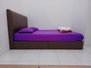 a bed in a room with purple sheets and pillows at Wany Homestay Free Wifi And Astro NJOI in Sungai Petani