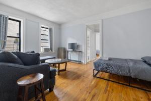een woonkamer met een bank en een bed bij Live Upper Manhattan on a Budget in New York
