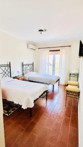 a bedroom with two beds and a chair in it at A Cista in Vila da Ponte