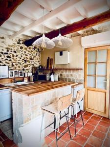 eine Küche mit einer Theke und Stühlen in einem Zimmer in der Unterkunft Maison Louisa 