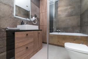 łazienka z umywalką, toaletą i wanną w obiekcie Przytulny Loft W Uroczej Okolicy w mieście Gliwice
