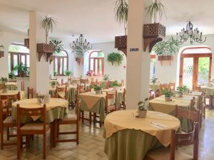 a dining room with tables and chairs and chandeliers at Villa Ciccio in Ischia