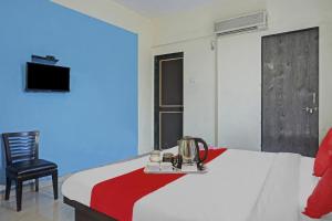 a hotel room with a bed and a chair at R K Exclusive in Hinjewadi