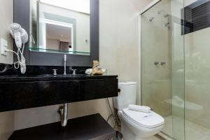 Un baño con inodoro, lavabo y ducha. en AION 302 - Vista al Mar - Piscina y Gimnasio Con Vista Panoramica, en Bombinhas