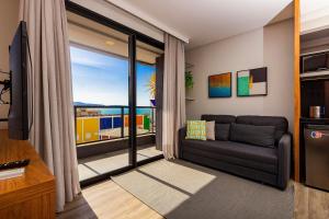 Una sala de estar con un sofá y una ventana grande. en AION 302 - Vista al Mar - Piscina y Gimnasio Con Vista Panoramica, en Bombinhas 17 fotos más