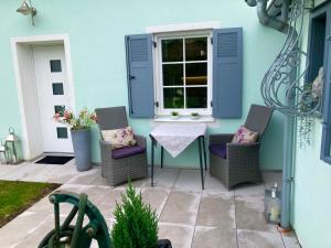 eine Terrasse mit Stühlen, einem Tisch und einem Fenster in der Unterkunft Steyr City Apartment mit 2 Schlafzimmer in Steyr