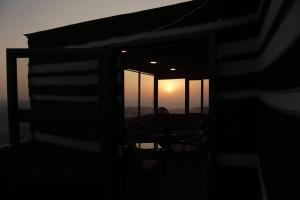 a view of a room with a sunset through a window at Plaza View Hostel in Taiyiba